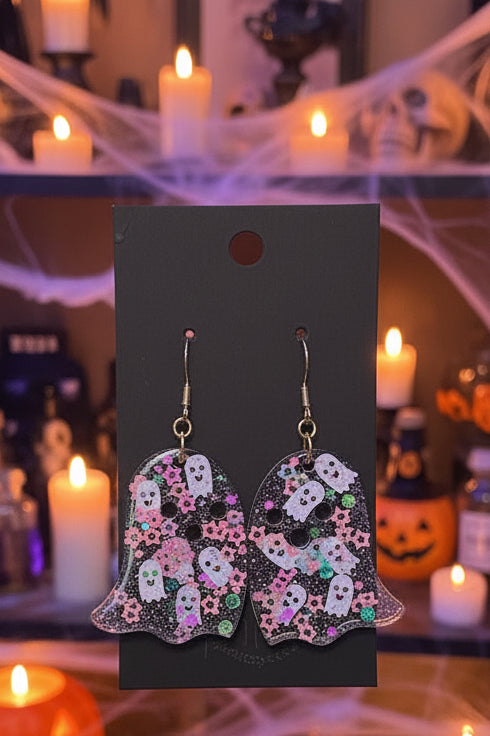 sparkling see-through whimsical ghost earring hung on gold hooks placed on a black earring card