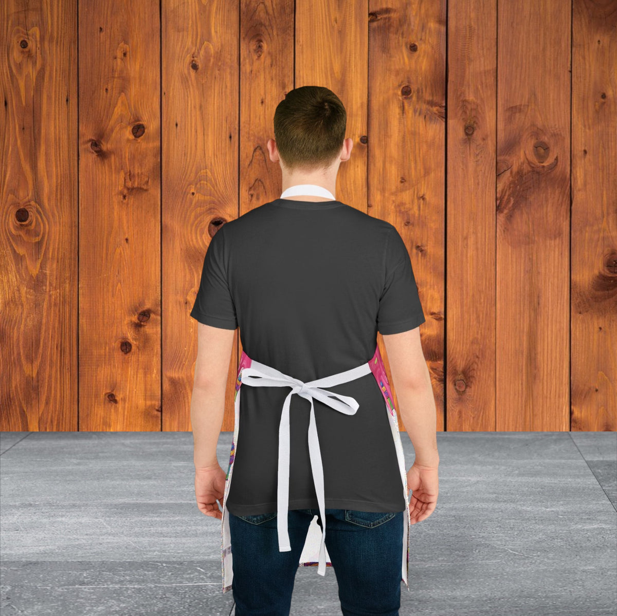 Jamrozy's Limited Company chef apron with white straps worn by a man against a rustic wooden wall background
